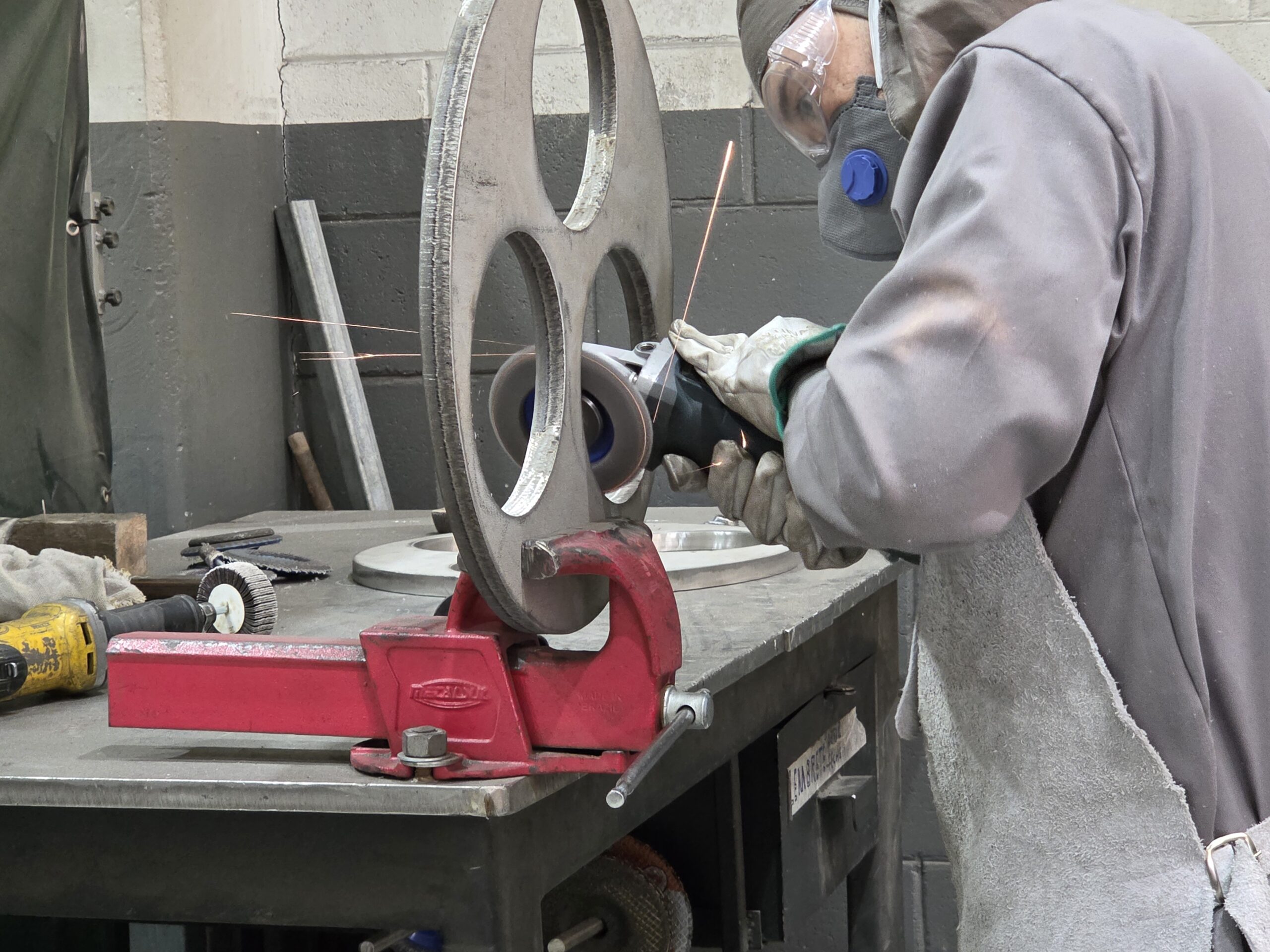 Técnico realizando o acabamento e a fabricação de componentes de um filtro industrial sob demanda em oficina especializada.
